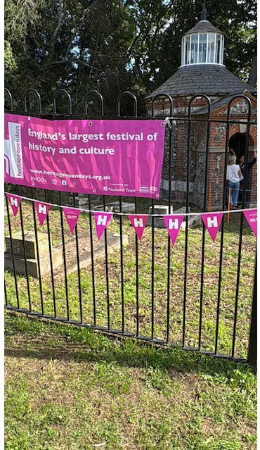Hales Place Chapel behind its railings on the Heritage Open Day, with a pink Heritage Open Days banner and bunting on the fence and visitors at the chapel door